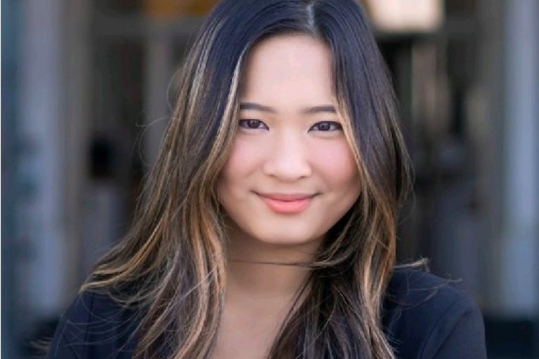 Photo of Nicole smiling and looking at the camera in formal attire
